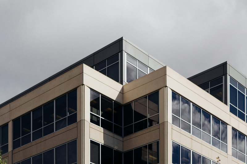 Modern low-rise office building with white panels and tall windows