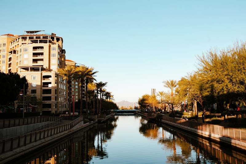 Buildings and palm trees reflected in the Arizona Canal in downtown Scottsdale