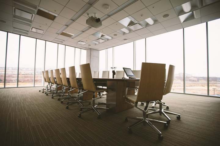 Conference room with a long wooden table and floor-to-ceiling windows