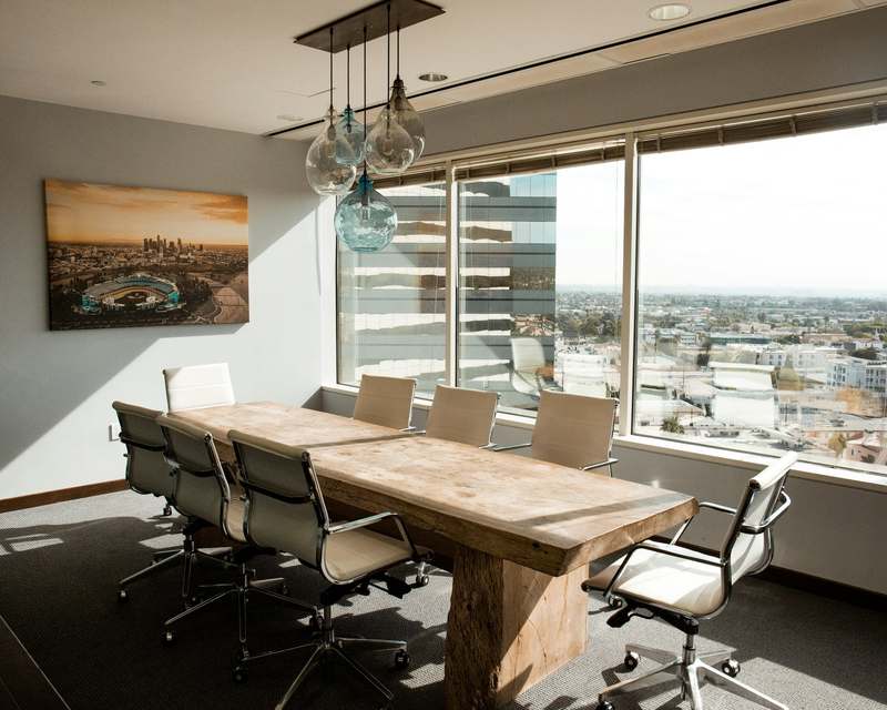 Meeting room with a long wooden table and leather chairs beside large windows